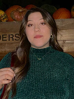 Person sitting with pumpkins background.