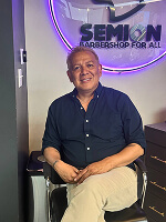 Person sitting in barbershop chair.