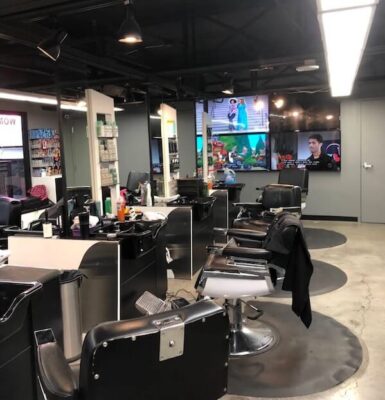Modern salon with styling chairs and screens.