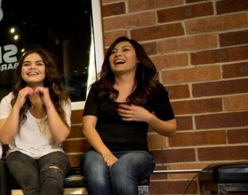 Two women sitting indoors, casual attire.