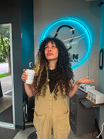 Person holding coffee in cafe.