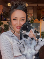 Person holding a cat indoors.