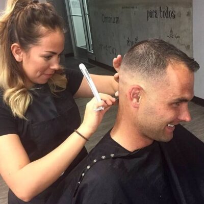 Person getting a haircut in salon.